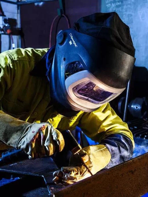 Apprentice welder in an engineering production class.